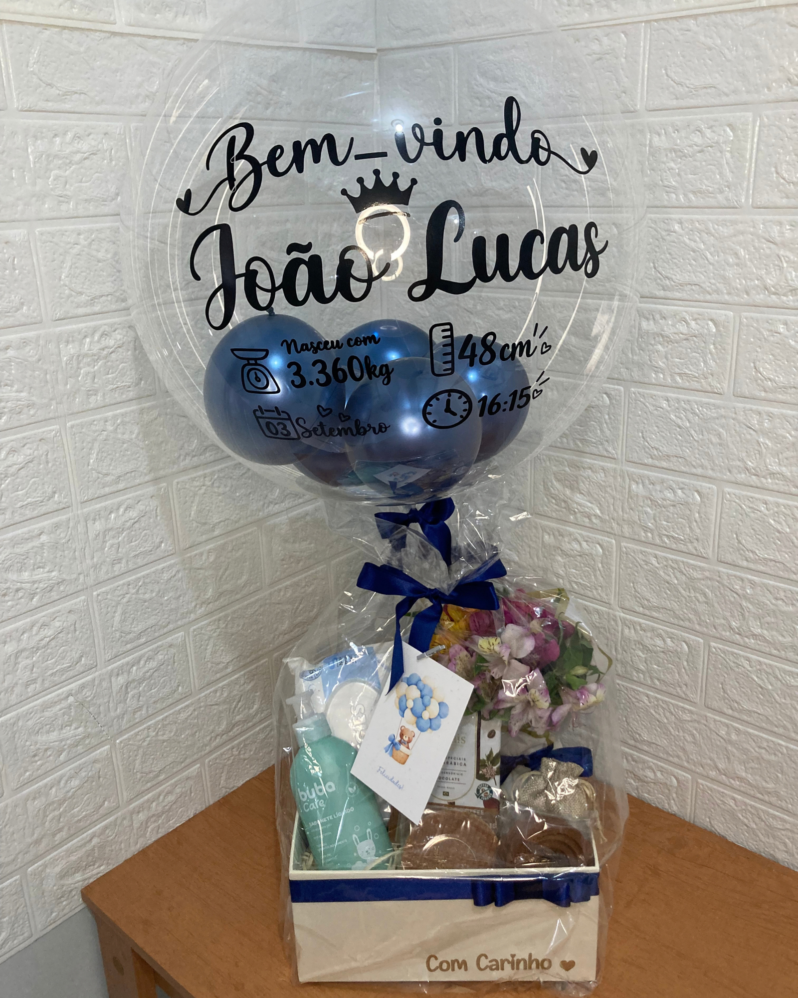 Cesta Maternidade 1 Box Maternidade contendo itens de higiene para recém-nascido, doces finos para os pais e balão personalizado com dados do nascimento.